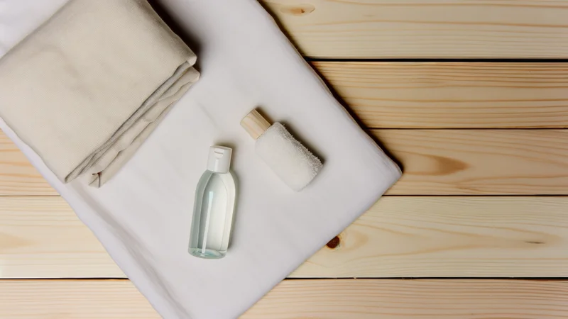 清潔な白いリネンと天然由来のボディケア用品が並ぶ落ち着いたフラットレイ写真