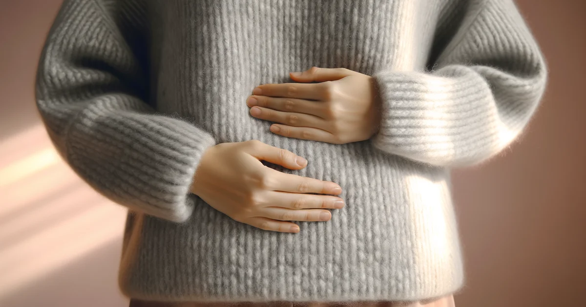 下腹部をおさえてうずくまる女性。月経困難症・重い生理痛のイメージ