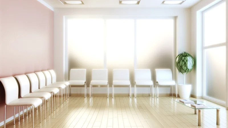 白い椅子と観葉植物が並ぶ明るい病院の待合室。安心感のある清潔な空間、受診・相談イメージ