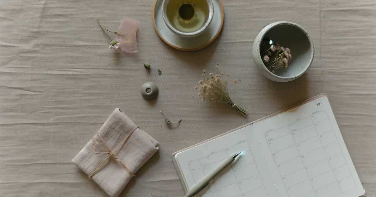 カレンダーと花が並ぶ穏やかなデスク。生理周期の管理をイメージした日常シーン