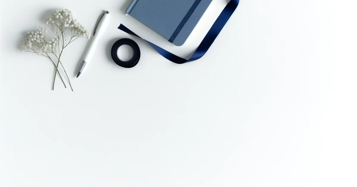 ネイビーリボン・かすみ草・ネイビーのノートとシルバーペンが白い背景に並ぶフラットレイ